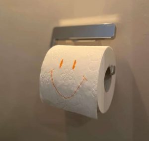 Toilettenpapierrolle mit lächelndem Gesicht