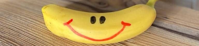 Gelbe Banane für gesunde Ernährung mit lächelndem Gesicht bemalt