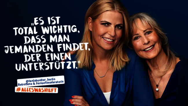 Tanja Bülter mit ihrer Mutter, die helfend den Arm um sie legt. Beide sind blau gekleidet und lächeln